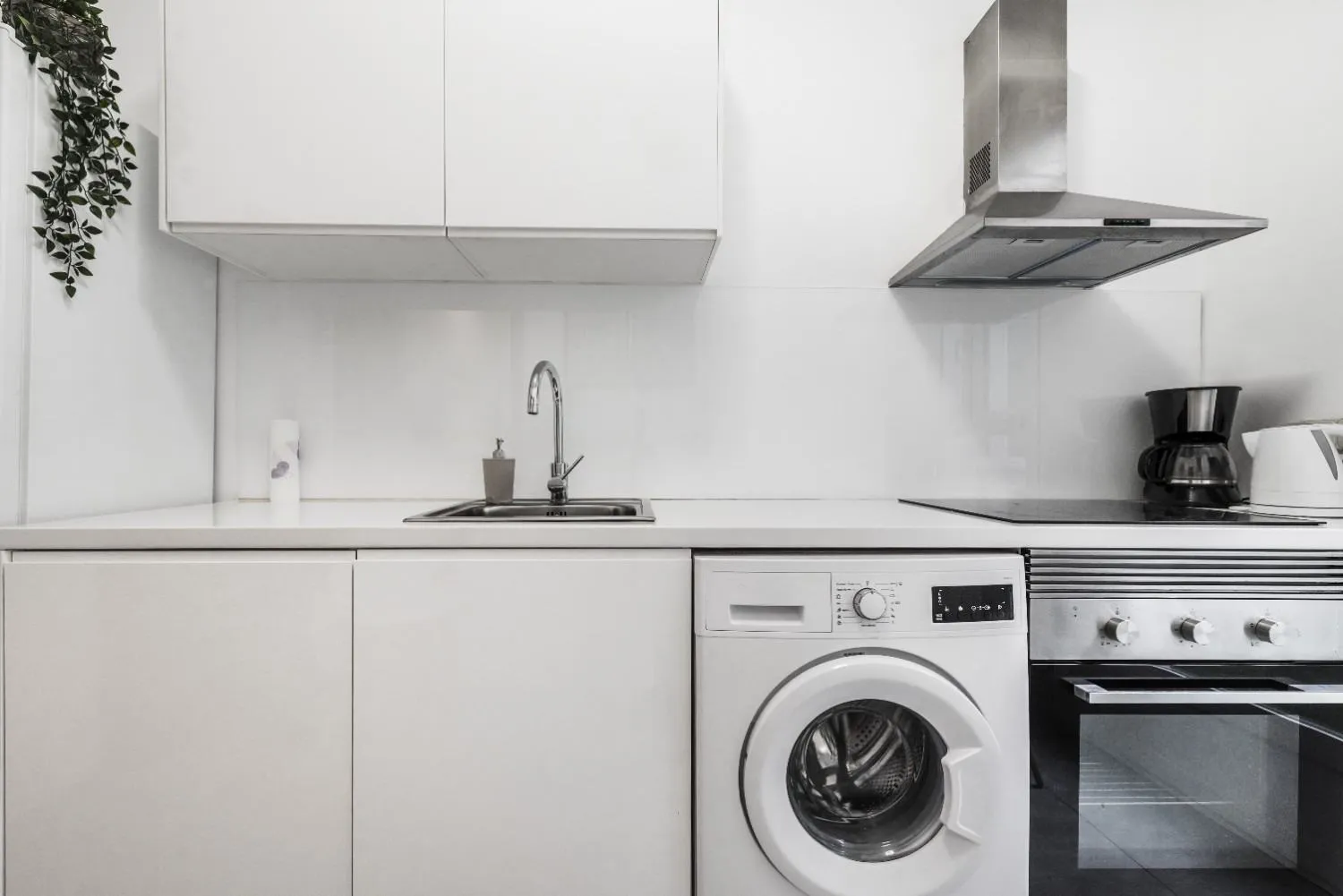Kitchen with a washer, oven and cooktop